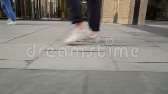 从地面一级的白色男子运动鞋沿路面行走视频的预览图