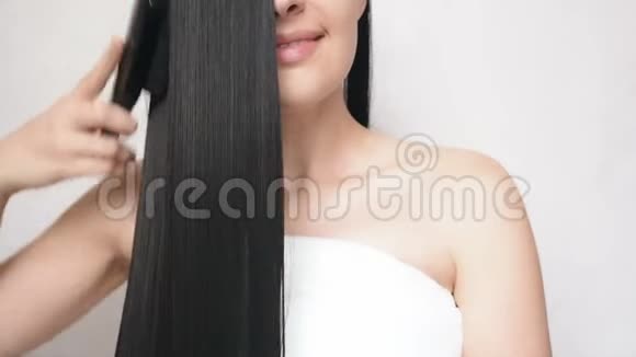 年轻的女孩梳着长长的光滑的头发后做了一个淋浴并显示了双手手势的心美丽的女士头发视频的预览图