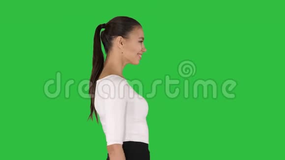 美丽而优雅的西班牙裔商务女性在绿色的屏幕上行走和微笑键视频的预览图