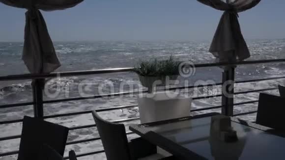 从汹涌的大海上的夏日餐厅的露台上观看视频的预览图