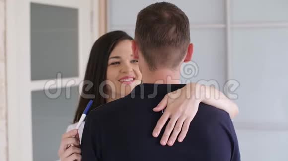 怀孕测试的女人拥抱她的丈夫视频的预览图