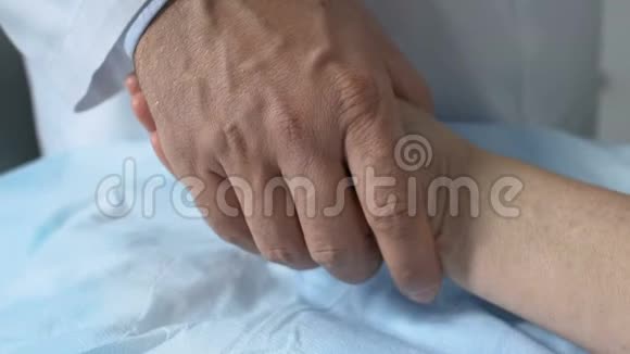 男性医生把失去知觉的女性病人手放在床上这是一项艰苦的职业视频的预览图