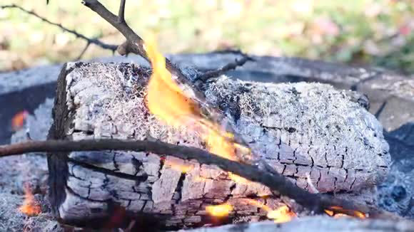 白色圆木缓慢转动变成灰烬在室外燃烧视频的预览图