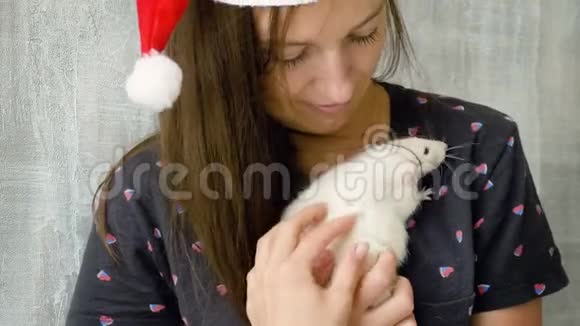 戴着白色老鼠红色圣诞帽的女人视频的预览图