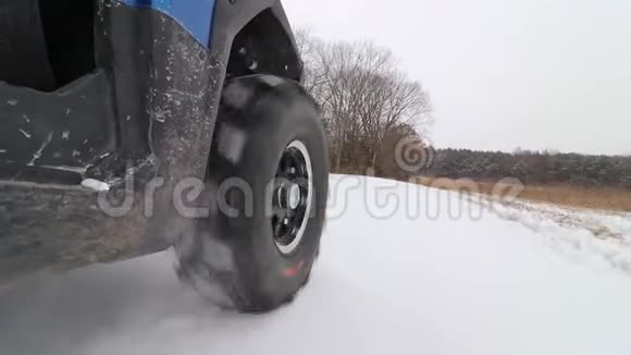 一辆并排的ATV在雪地里的乡村道路上行驶视频的预览图