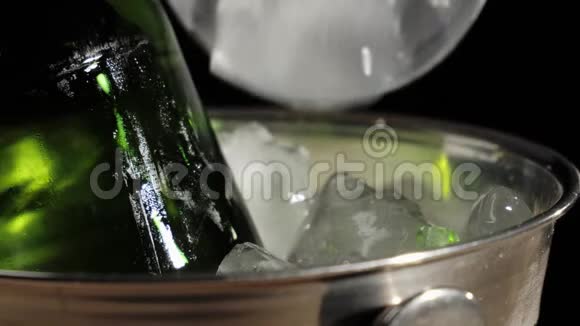 新鲜啤酒用勺子把冰冷的冰倒进一桶美味的手工啤酒放在绿色的瓶子里背景是黑色的视频的预览图