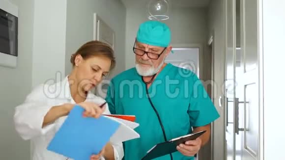 两个医生男人和女人正在诊所的走廊里交谈医疗保健概念视频的预览图