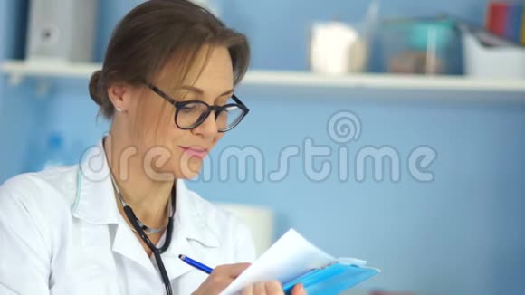 戴眼镜的严格职业女医生的肖像穿白色外套的文件夹国际医生日视频的预览图