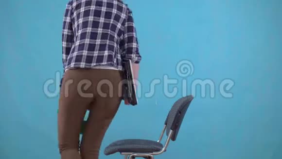 女人坐在蓝色背景的椅子上的矫形枕头上痔疮的概念视频的预览图
