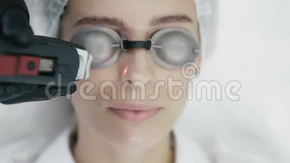 用特殊设备把美容医生的手闭上做激光手术去除女孩脸上血管视频的预览图