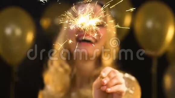 漂亮的金发女郎在派对上的彩纸下挥舞着孟加拉灯视频的预览图