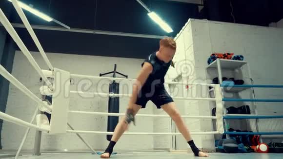 职业年轻的拳击手在拳击俱乐部的环边训练前正在热身视频的预览图