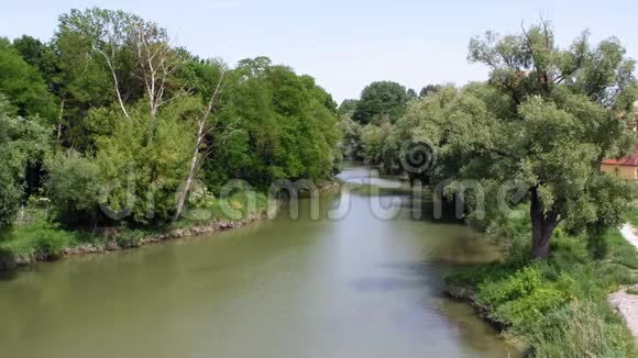 夏天从德国雷根斯堡的一座桥上看到多瑙河两岸长满了茂密的绿树视频的预览图