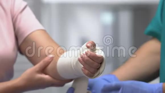 医生用弹力绷带包扎女性患者手臂关节脱位视频的预览图