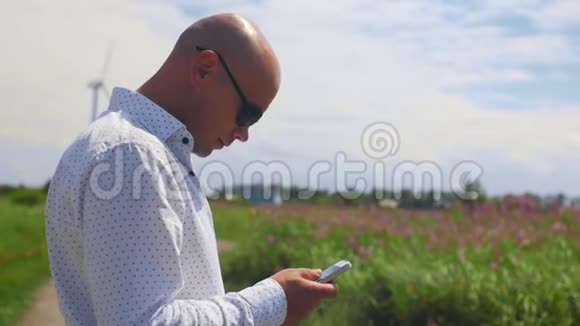 男人使用和滚动电话环顾四周的背景一个乡村道路夏天中弹视频的预览图