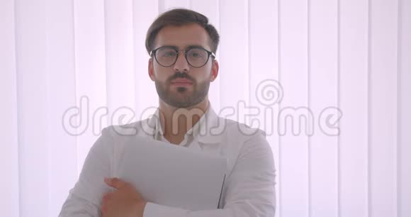 一位英俊成功的高加索商人戴着眼镜手持笔记本电脑看着白色相机的特写肖像视频的预览图