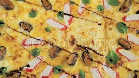 一个披萨的特写上面有奶酪奶酪和蟹肉棒围绕着自己旋转从顶部可以看到视频的预览图