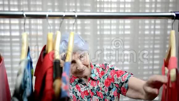 女售货员在衣服架附近轻拍一位老妇人的肩膀视频的预览图