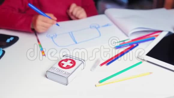 一个儿童急救箱躺在学校一个男孩旁边的桌子上视频的预览图