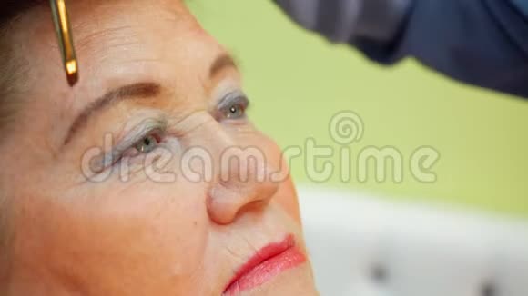 在美工坊里化妆眉毛的时候面对一位年长的女士视频的预览图