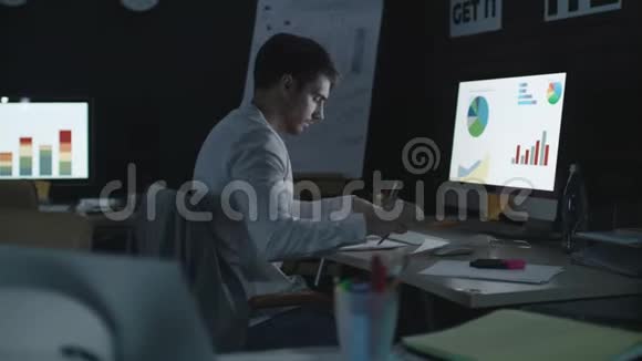 专业商人分析夜间办公室的财务图表和数据视频的预览图