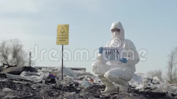 危险生物学家穿防护服表明垃圾堆场上有绿色标志露天有辐射危险视频的预览图