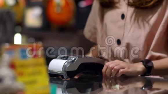 年轻女子用智能手表在柜台上支付工资视频的预览图