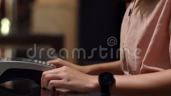 年轻女子用智能手表在柜台上支付工资视频的预览图
