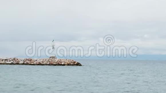 在岩石海岸和平静的海水上孤独的灯塔视频的预览图