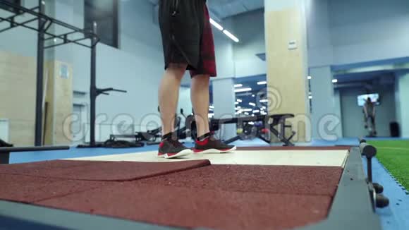 肌肉男在健身房里用慢速投掷沉重的杠铃视频的预览图