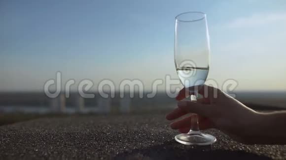 女士手拿一杯香槟在阳台上欣赏城市美景享受生活方式视频的预览图
