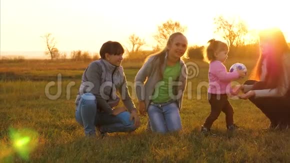 妈妈和小女儿在舞会上玩慢动作快乐的孩子在草地上带着球跑家庭玩小游戏视频的预览图