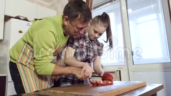 一位父亲教他患有唐氏综合症的女儿如何切蔬菜视频的预览图