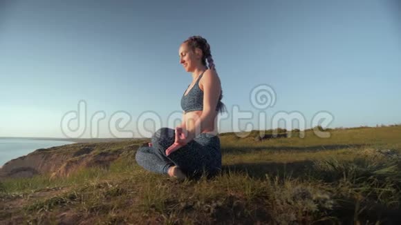 瑜伽爱好运动情侣一起在山顶上以莲花姿势在天空背景下冥想视频的预览图