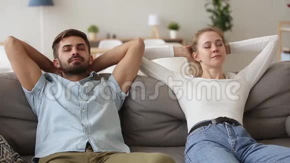 平静的年轻夫妇在舒适的沙发上休息放松视频的预览图