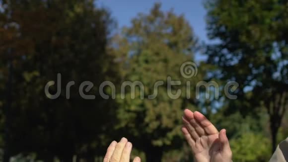 老人和女人伸出高五双手打招呼团结视频的预览图