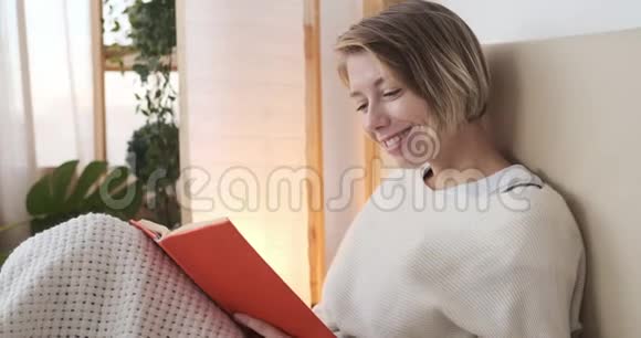 快乐的女人在床上看书视频的预览图