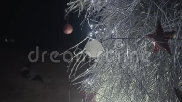 新年树有玩具和仙女灯在海滩上特写视频的预览图