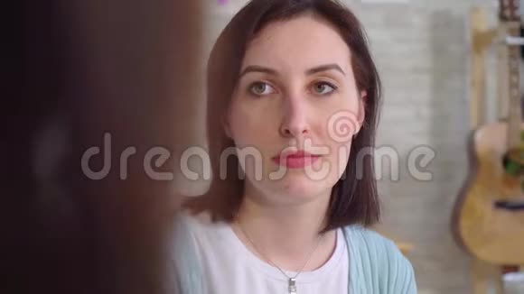 在客厅里漂亮的聋人年轻女性使用手语视频的预览图
