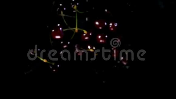 果汁樱桃在黑色背景下飞上水面视频的预览图