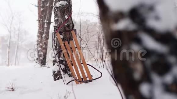 老式木制雪橇由云杉支撑在雪冬森林节日的圣诞节雪背景与旧雪橇视频的预览图