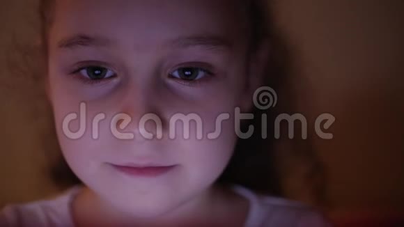 一个可爱的白种人小女孩特写一个孩子的的脸看着一台平板电脑与光和反射视频的预览图