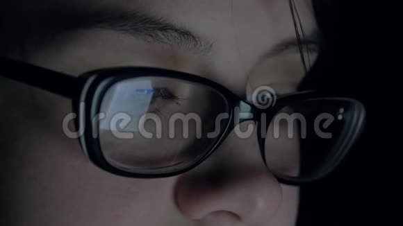 女人在晚上使用平板电脑屏幕上的眼镜会显示出来视频的预览图