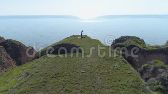 瑜伽户外活动强壮的瑜伽男子和灵活的女人在海边的草地上做伸展运动视频的预览图