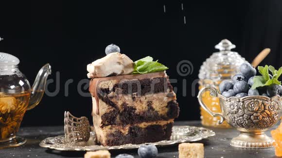 粉糖落在美味的蛋糕上茶罐与绿茶和玻璃罐与蜂蜜在背景慢慢视频的预览图