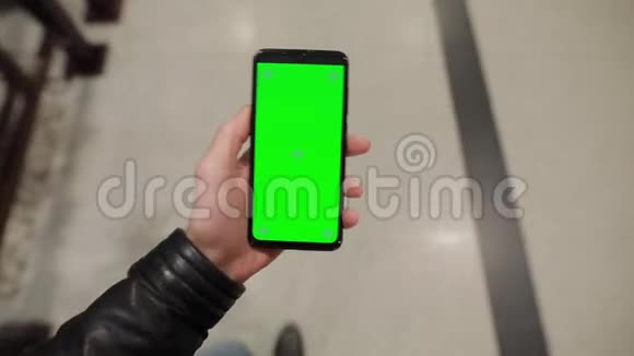 Pov男性手持智能手机绿色屏幕在商场里行走视频的预览图