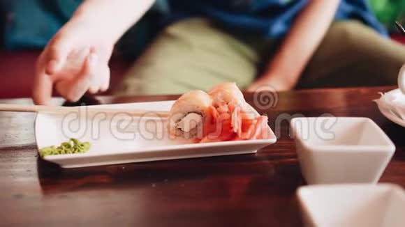 男孩用筷子吃寿司蘸酱油漂亮的慢动作框架咖啡馆里的父子通信视频的预览图
