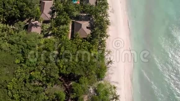 海波绿棕沙滩上的酒店房屋和度假空中风景视频的预览图