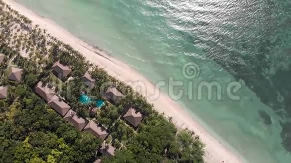 海波绿棕沙滩上的酒店房屋和度假空中风景视频的预览图