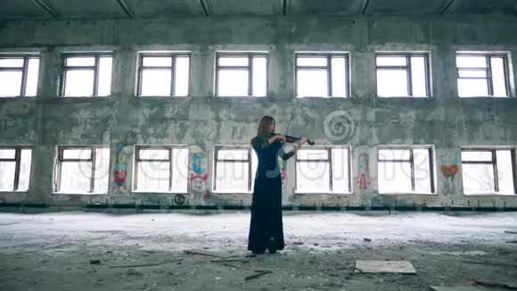 女小提琴手在破旧的大厅里演奏乐器视频的预览图